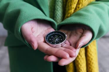 Die Hände einer Frau halten einen Navigationskompass - ASGF02055