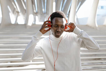Junger Mann hört Musik über Kopfhörer - TCEF02151