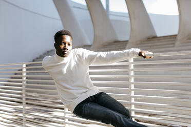 Carefree man leaning on white railing - TCEF02159