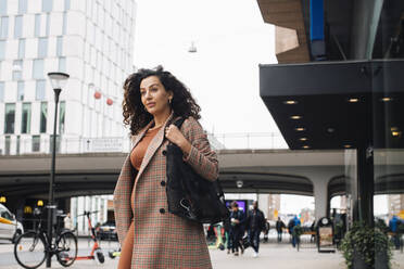 Businesswoman walking on street while going to work - MASF28011