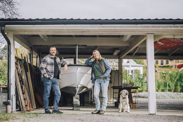 Porträt von männlichen und weiblichen Freunden mit Hund in der Garage - MASF28128