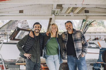 Portrait of smiling family with arms around in garage - MASF28134