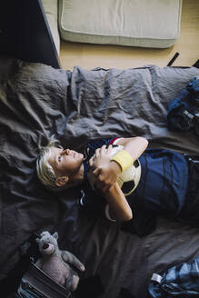 Directly above shot of boy contemplating while lying down in bedroom - MASF28172