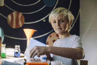 Porträt eines Jungen bei einem wissenschaftlichen Experiment zu Hause - MASF28190