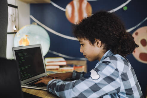 Konzentriertes Mädchen lernt zu Hause am Laptop Programmieren - MASF28210