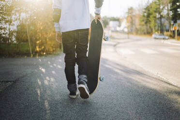 Tiefschnitt eines Jungen mit Skateboard auf der Straße - MASF28222