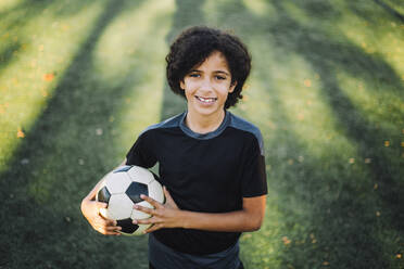 Porträt eines Mädchens mit Fußball auf einem Sportplatz - MASF28232