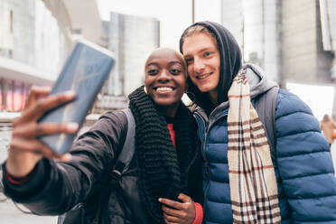 Italien, Lächelndes Paar, das ein Selfie in der Stadt macht - ISF25532