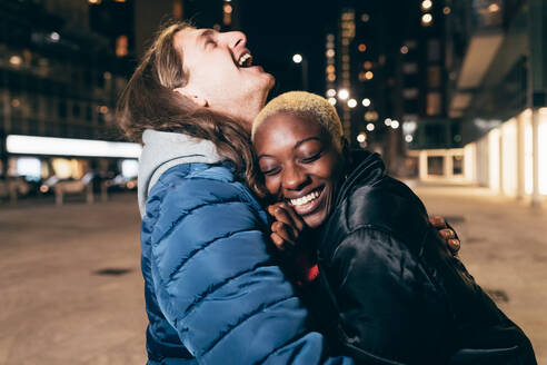 Italien, Glückliches Paar umarmt sich in der Stadt bei Nacht - ISF25533