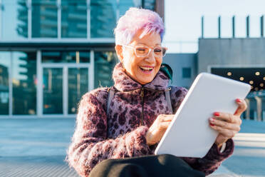 Italien, Lächelnde, modische ältere Frau mit digitalem Tablet in der Stadt - ISF25546