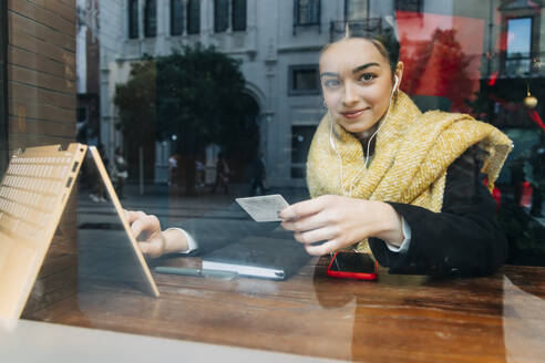 Lächelndes Teenager-Mädchen beim Online-Shopping am Laptop im Café - JRVF02357