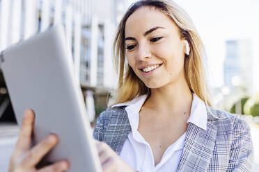 Smiling young businesswoman using tablet PC - XLGF02483