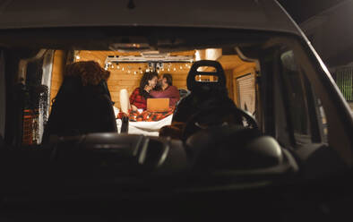 Man kissing girlfriend in camper van on vacation - EGHF00301