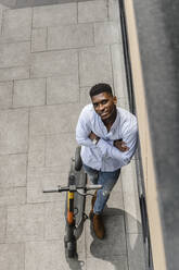 Young man with arms crossed on footpath - VYF00915