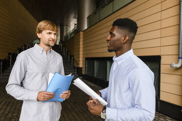 Friends with documents talking on footpath - VYF00922