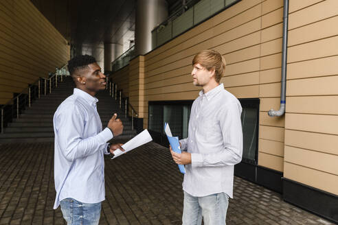 Junger Mann diskutiert mit einem Freund auf dem Fußweg - VYF00923