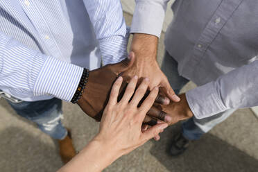 Multirassische Freunde beim Stapeln der Hände auf dem Fußweg - VYF00941