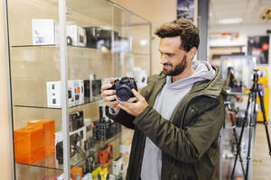 Smiling customer looking at camera in shop - DAWF02393