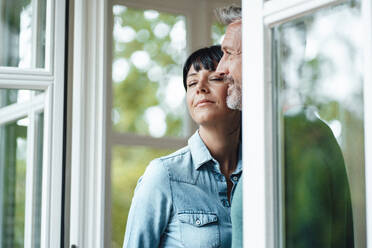 Thoughtful man with woman by window - JOSEF06387