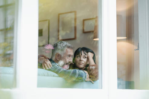 Heterosexual couple seen through window of house - JOSEF06422