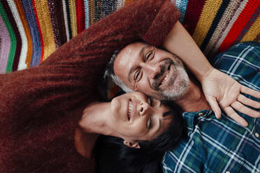 Smiling mature couple resting at home - JOSEF06451