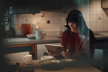 Lächelnde Frau mit Tablet-PC in der Küche - JOSEF06452