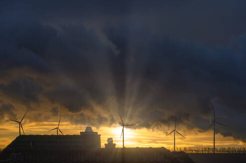 Deutschland, Nordrhein-Westfalen, Grevenbroich, Gewitterwolken über Windpark bei Sonnenaufgang - FRF00950