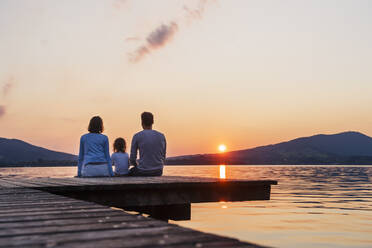 Familie mit Blick vom Steg bei Sonnenuntergang, Mondsee, Österreich - DIGF17411