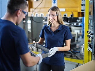 Lächelnde Techniker mit Metallrahmen in der Fabrik - CVF01784