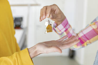 Woman giving house key to man - JCCMF05019
