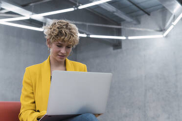 Blonde Geschäftsfrau arbeitet am Laptop im Büro - PNAF02725