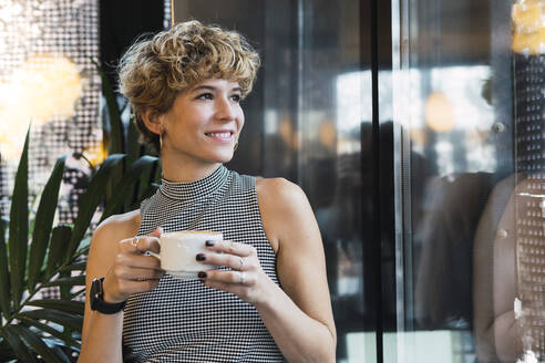 Thoughtful woman with coffee cup at cafe - PNAF02755