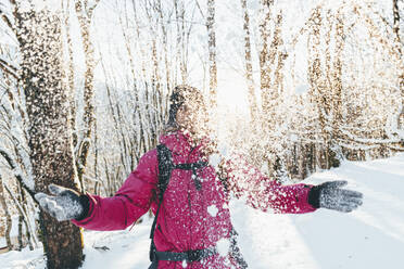 Verspielter Mann wirft Schnee im Winterwald - OMIF00364