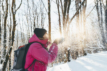 Tourist blowing snow in forest at vacation - OMIF00365