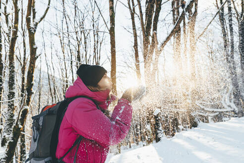 Tourist beim Schneeschaufeln im Wald im Urlaub - OMIF00365