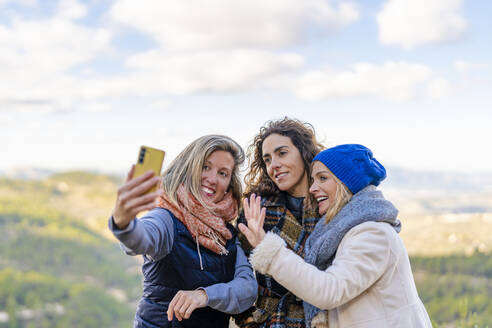Frau macht Selfie mit Freunden im Park - DLTSF02538