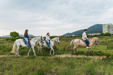 Junge Freunde reiten auf Pferden im Gras - RSGF00792