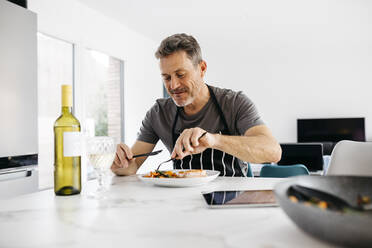 Hungry man eating food at home - JRFF05262