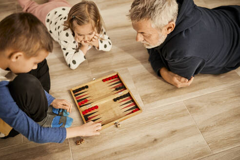 Großvater spielt Backgammon mit seinen Enkelkindern zu Hause - ZEDF04367