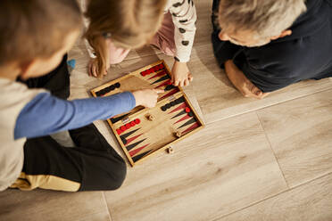 Kinder spielen Backgammon mit ihrem Großvater zu Hause - ZEDF04370