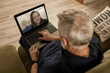 Man doing video call on laptop at home - ZEDF04412
