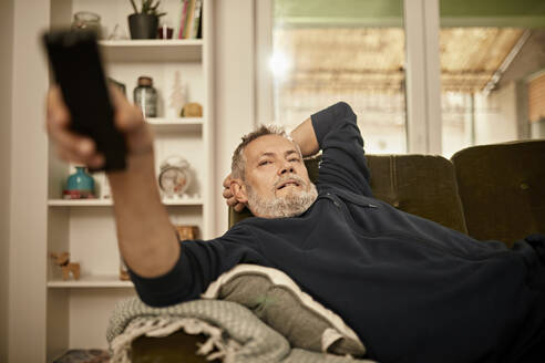 Relaxed man watching TV at home - ZEDF04417