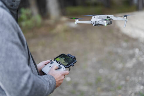 Pilotdrohne fliegt durch funkgesteuerten Handapparat im Park - DLTSF02583