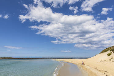 Australien, Victoria, Port Fairy, Sommerwolken über einer Touristin beim Wandern am Sandstrand im Port Fairy Coastline Protection Reserve - FOF12572