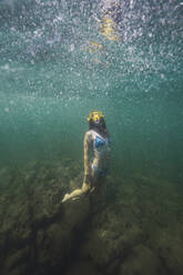 Young woman in bikini swimming undersea - RSGF00805