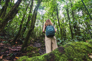 Junger Wanderer mit Rucksack auf Erkundungstour im grünen Wald im Arenal Volcano National Park, La Fortuna, Provinz Alajuela, Costa Rica - RSGF00817