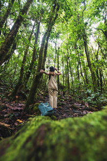 Abenteuerlustige Frau bei einer Erkundungstour durch den Wald im Arenal Volcano National Park, La Fortuna, Provinz Alajuela, Costa Rica - RSGF00818