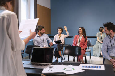 Geschäftsfrau hebt die Hand bei einem Treffen im Büro - EIF02991