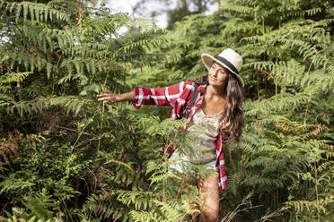 Frau erkundet grünen Wald in Cannock Chase an einem sonnigen Tag - WPEF05650