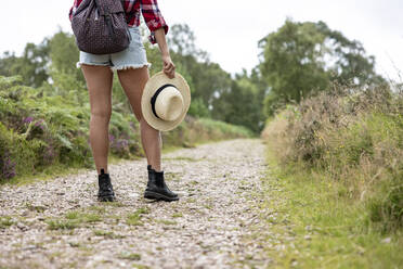 Frau mit Rucksack und Hut auf dem Fußweg in Cannock Chase - WPEF05666